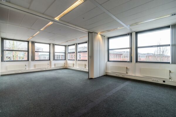 Lichte, lege kantoorruimte aan de Lange Dreef met grote ramen en uitzicht op omliggende gebouwen.